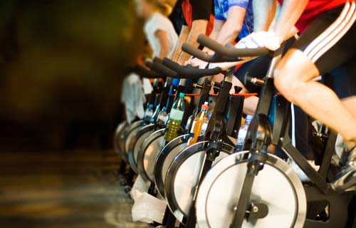Personer der cardio-træner på spinning cykler